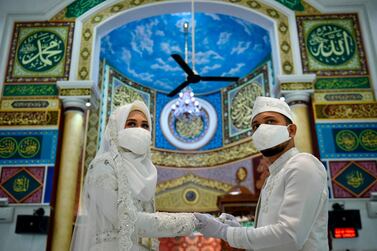 A couple wearing face masks amid the COVID-19 coronavirus get married at a wedding ceremony at a mosque in Banda Aceh earlier this month. AFP    