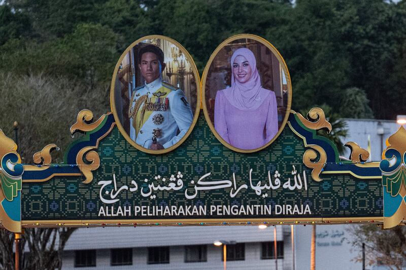 The portraits of Prince Abdul Mateen and bride Anisha Rosnah with a slogan that reads 'God protect the royal couple' are pictured on a billboard over a road on Borneo island in Brunei. AFP