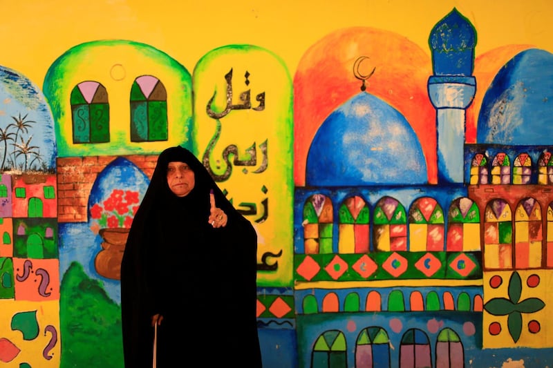 An Iraqi woman shows her ink-stained finger after casting her vote at a polling station during the parliamentary election in the Sadr city district of Baghdad. Thaier al-Sudani / Reuters