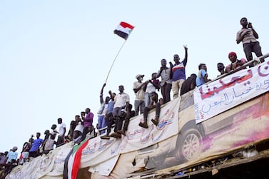 Demonstrators wave their national flag as they attend a protest rally demanding Sudanese President Omar Al-Bashir to step down outside Defence Ministry in Khartoum. Reuters