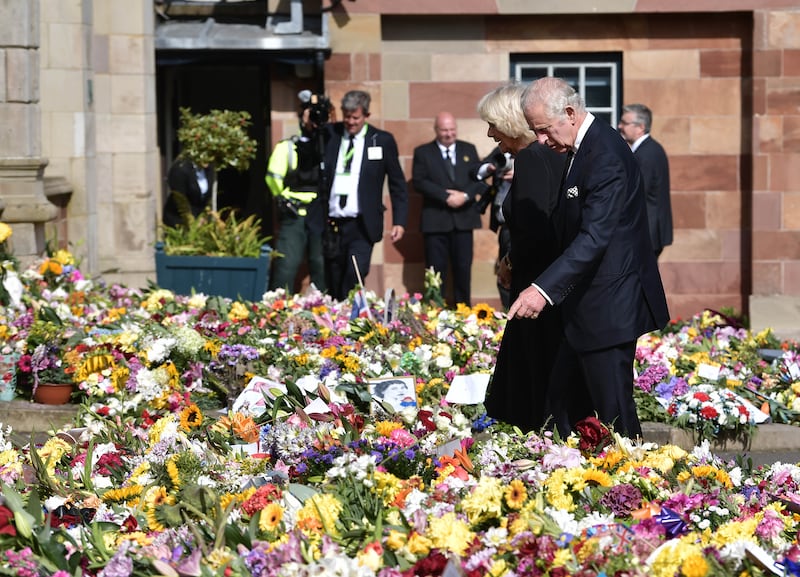 King Charles III and Queen Consort Camilla inspect floral tributes left for his late mother Queen Elizabeth II outside Hillsborough Castle in Northern Ireland. Getty