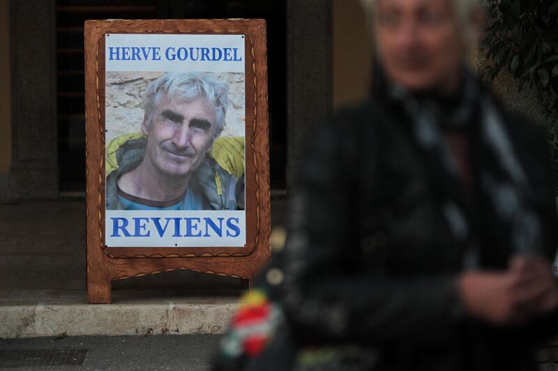 (FILES) This file picture taken on September 23, 2014 shows a poster depicting Herve Gourdel, 55, a mountain guide who was seized on September 21 evening while trekking in the rugged, heavily forested Kabylie area, where Al-Qaeda is active, and reading "Herve Gourdel, come back", in front of the town hall of Saint-Martin-Vesubie, southeastern France. The trial for the assassination of French mountain guide Herve Gourdel, who was kidnapped and beheaded in 2014 by jihadists in Algeria, will begin on February 4, 2021 in Algiers. / AFP / Jean-Christophe MAGNENET
