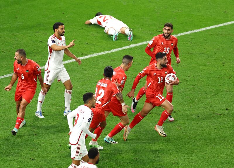 Palestine players celebrate after UAE's Bader Nasser, on ground, scored an own goal. Reuters