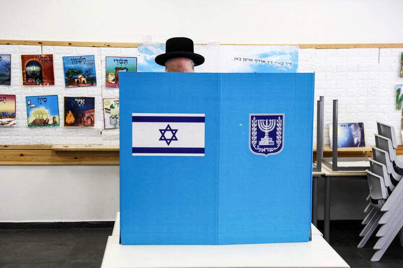 An Ultra-Orthodox Jewish Israeli selects his ballot paper on the day of Israel's general election in a polling station in Jerusalem. Reuters