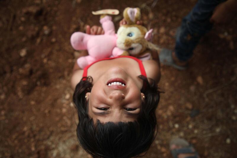 A Syrian girl carries a toy that was given to her by a Syrian man living in Finland and calling himself "The Toy Smuggler", after he distributed toys to children at a DIP camp for Interally Displaced Persons near the town of Aqrabat in Syria's northern Idlib province. AFP