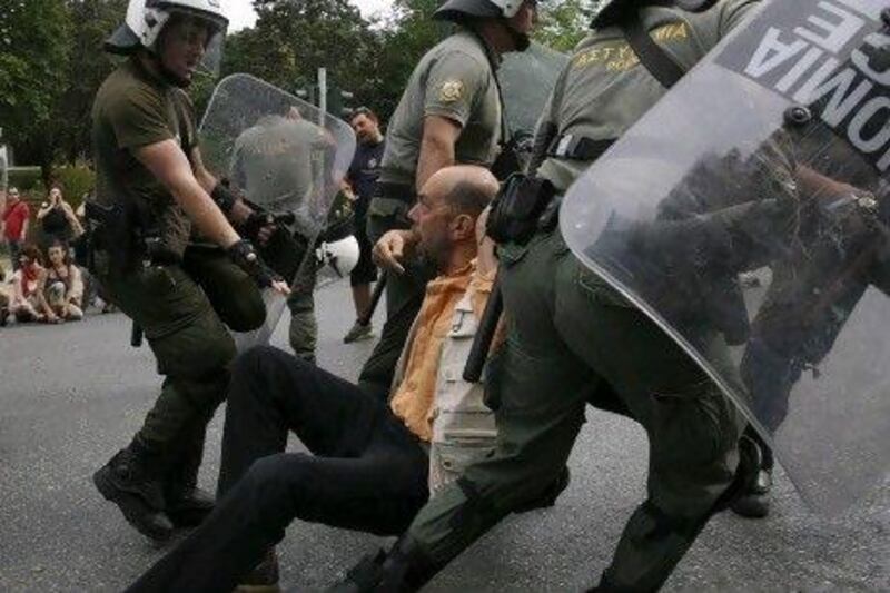 Police arrest a demonstrator who tried to block the road to the Parliament during a rally in Athens. AP Photo