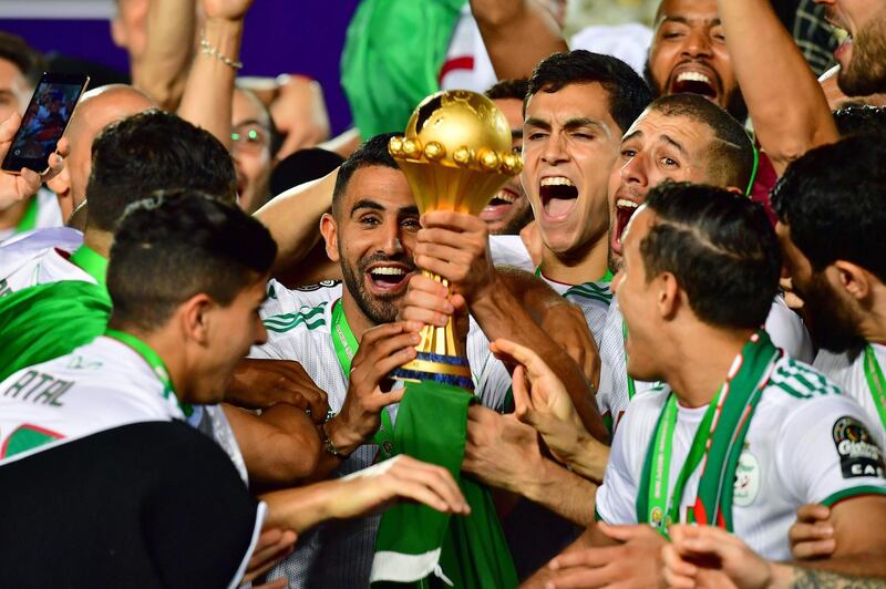 TOPSHOT - Algeria's forward Riyad Mahrez and his teammates celebrate with the trophy after winning the 2019 Africa Cup of Nations (CAN) Final football match between Senegal and Algeria at the Cairo International Stadium in Cairo on July 19, 2019.  / AFP / Giuseppe CACACE
