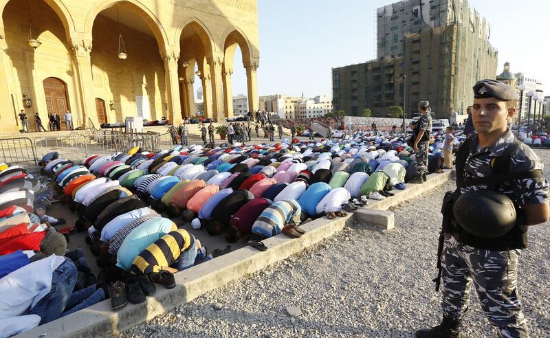 Lebanese security forces keep watch as Muslim worshippers perform Eid al-Fitr prayers outside the Mohammad al-Amin mosque in Beirut on July 6, 2016. - Muslims worldwide celebrate Eid al-Fitr marking the end of the fasting month of Ramadan. (Photo by ANWAR AMRO / AFP)