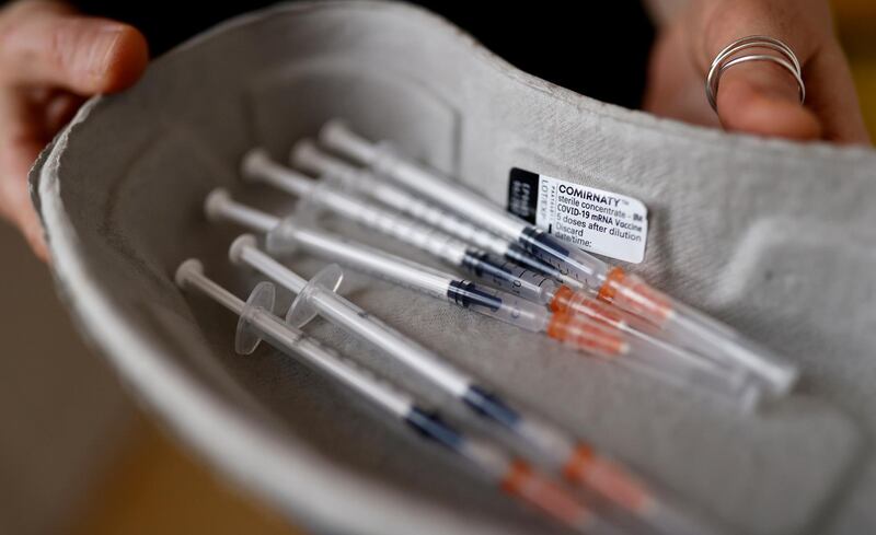 FILE PHOTO: A health worker holds prepared syringes with doses of the "Comirnaty" Pfizer-BioNTech COVID-19 vaccine at Paris 3rd district city hall as part of the coronavirus disease (COVID-19) vaccination campaign in France, March 7, 2021.    REUTERS/Christian Hartmann/File Photo