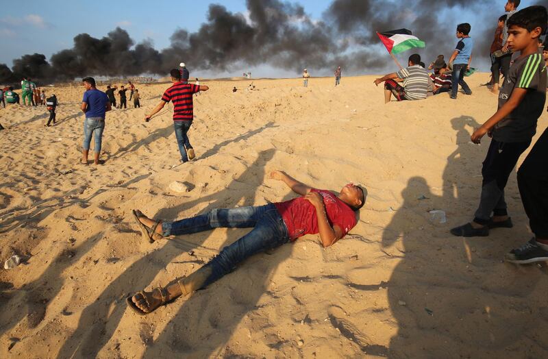 A Palestinian protestor lies on the beach near the maritime border with Israel, in the northern Gaza Strip, after Israeli forces fired tear gas canisters during a demonstration calling for the lift of the Israeli blockade on the coastal Palestinian enclave. AFP