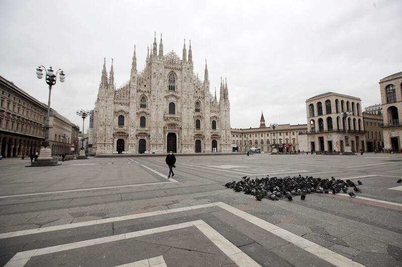 A woman crosses a nearly empty Duomo square in downtown Milan, Italy. AP Photo