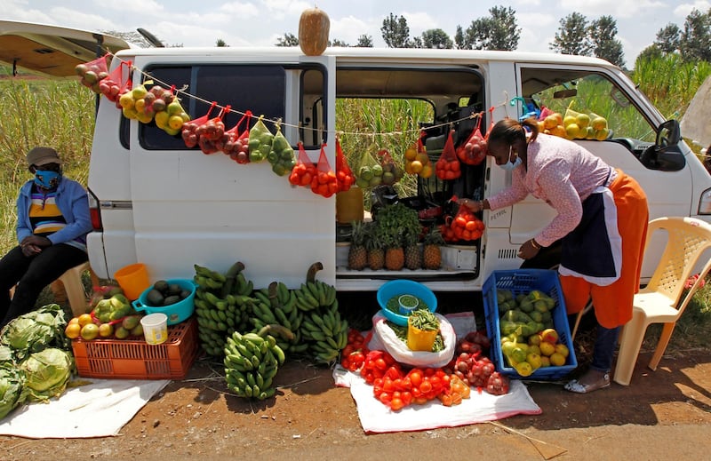 A motorist arranges fruits and vegetables for sale next to her vehicle, as an alternative mobile grocery stall on the outskirts of Nairobi, Kenya. Reuters