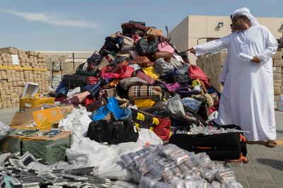DUBAI, UNITED ARAB EMIRATES, 08 FEBRUARY 2017. Ibrahim Behzad, Director of Intellectual Property Rights Management at DED looks through a pile of counterfeit products at the DED in Al Garhoud. The products are scheduled to be distroyed and recycled. (Photo: Antonie Robertson/The National) ID: 75938. Journalist: Nick. Section: National. *** Local Caption ***  AR_0802_Fake_Goods-09.JPG