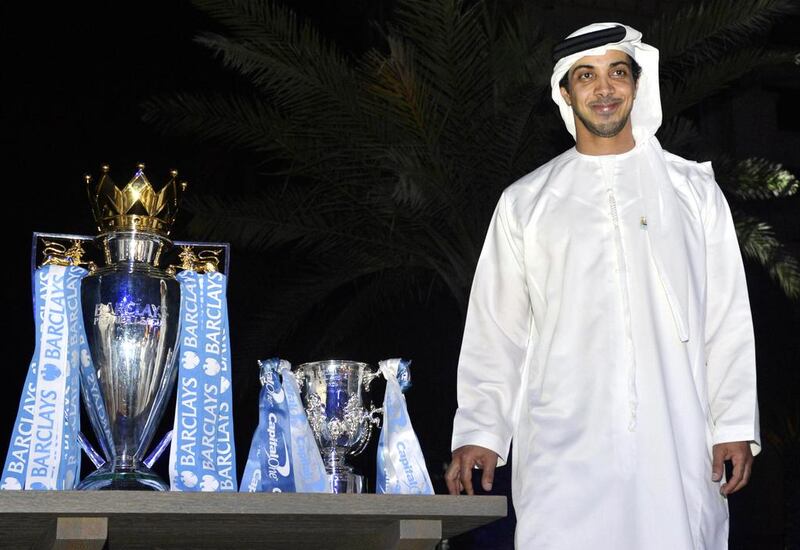 Sheikh Mansour with the Capital One Cup and the Premier League title. 