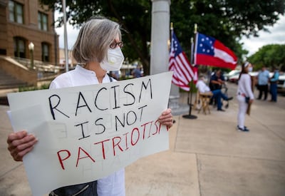 Marie Smith joins a group called "Allies rally against Confederate and police violence," gathered outside of the Williamson County courthouse at the Confederate statue on the courthouse lawn to protest for the removal of the statue, Thursday, June 18, 2020, in Georgetown, Texas. The group plans to be at the courthouse every Thursday protesting for the removal of the Confederate statue until it's removed. (Ricardo B. Brazziell/Austin American-Statesman via AP)