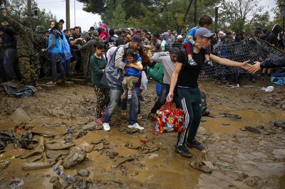 Syrian refugees walk through the mud as they cross the border from Greece into Macedonia, near the Greek village of Idomeni, September 10, 2015. Reuters and The New York Times shared the Pulitzer Prize for breaking news photography for images of the migrant crisis in Europe and the Middle East. REUTERS/Yannis Behrakis      TPX IMAGES OF THE DAY      - RTX2AJJB