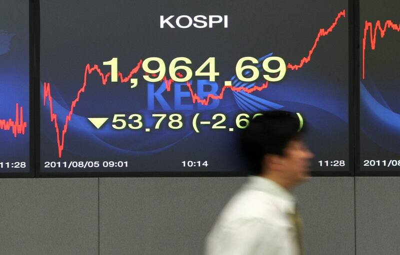 A foreign currency dealer walks past a monitor displaying the Korea Composite Stock Price Index (Kospi) in a dealing room at the headquarters of the Korea Exchange Bank in Seoul, South Korea, on Friday, Aug. 5, 2011. South Korea's won sank to a five-week low as concern the global economy is headed for a recession prompted overseas investors to pull funds from emerging markets. Photographer: SeongJoon Cho/Bloomberg *** Local Caption ***  887079.jpg