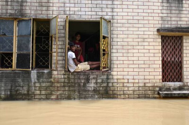Residents seek refuge inside their homes as the roads outside remain submerged by floodwaters in India's Paschim Medinipur district.