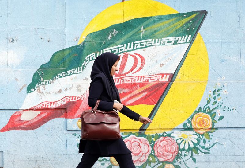 epaselect epa07138447 An Iranian woman walks past a mural depicting Iran's national flag in a street of Tehran, Iran, 03 November 2018. US President Donald J. Trump's administration announced on 02 November 2018, that it will reimpose sanctions against Iran that had been waived under the 2015 Iran nuclear deal (the Joint Comprehensive Plan of Action, JCPOA). The US sanctions will take effect on 05 November 2018, covering Iran's shipping, financial and energy sectors. In 2015, five nations, including the United States, worked out a deal with the Middle Eastern country that withdrew the sanctions, one of former US President Barack Obama's biggest diplomatic achievements.  EPA/ABEDIN TAHERKENAREH