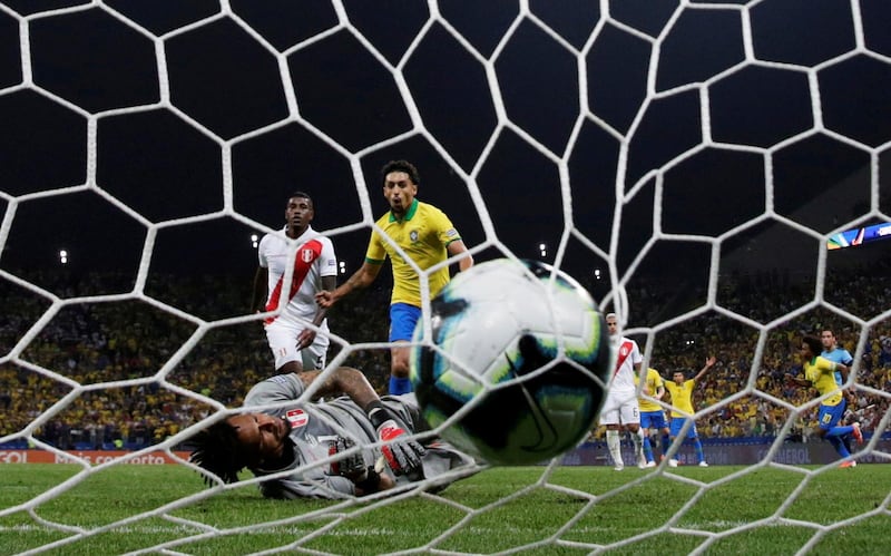 Brazil's Willian celebrates scoring their fifth goal with Marquinhos as Peru's Pedro Gallese looks dejected. Reuters