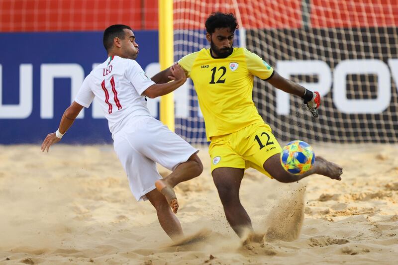 Leo Martins (L) of Portugal vies for the ball with Younis Al Owaisi, goalkeeper of Oman. EPA