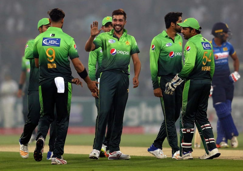 Pakistan's Mohammad Amir, center, celebrates with teammates after taking the wicket of Sri Lankan batsman Dilshan Munaweera during their third Twenty20 international match at the Gaddafi stadium in Lahore, Pakistan, Sunday, Oct. 29, 2017. (AP Photo/K.M. Chaudary)