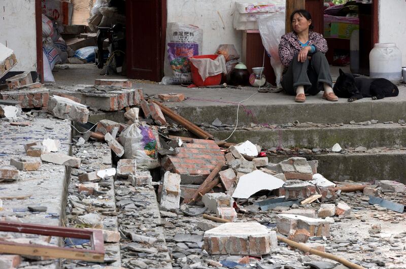 A woman looks over at her destroyed house in Gucheng village in Longmen county of southwestern China's Sichuan province, Sunday, April 21, 2013. Rescuers and relief teams struggled to rush supplies into the rural hills of China's Sichuan province Sunday after an earthquake prompted frightened survivors to spend a night in cars, tents and makeshift shelters.  (AP Photo/Ng Han Guan) *** Local Caption ***  China Earthquake.JPEG-0760b.jpg