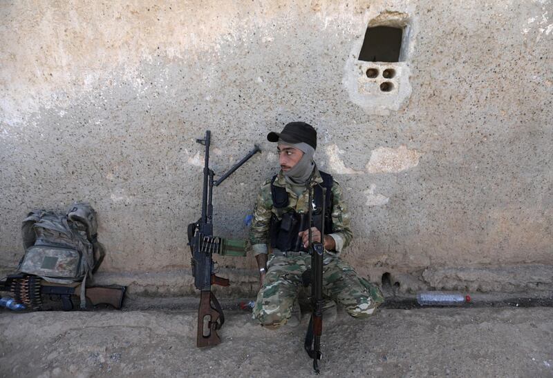 A Turkey-backed Syrian rebel fighter sits with his weapon near the border town of Tel Abyad, Syria. REUTERS