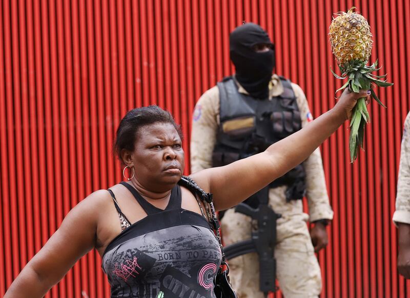A woman sells pineapple in Port-au-Prince, Haiti, during protests about the rising cost of phone services and a growing wave of kidnappings. The protests come days after the abduction of a group of American and Canadian missionaries. Reuters