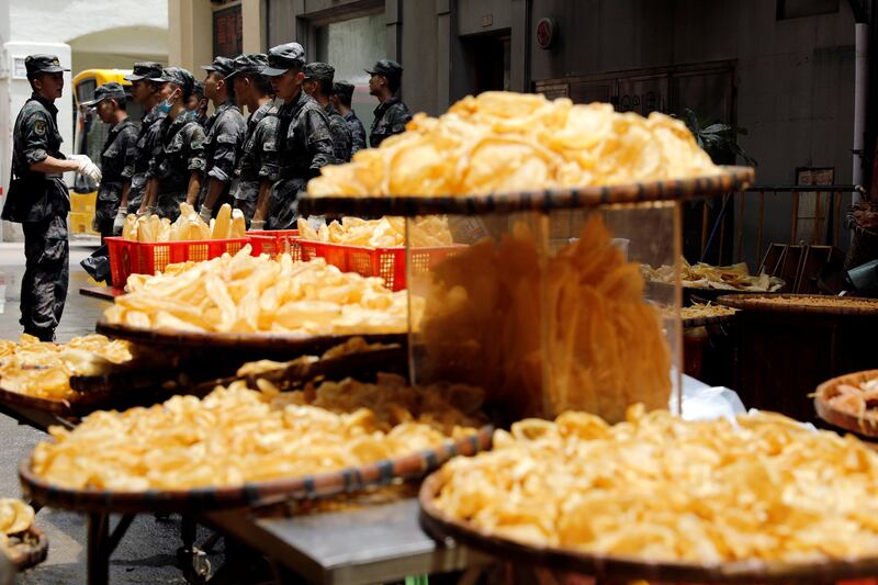 People’s Liberation Army soldiers stand near dried seafood after Typhoon Hato hits in Macau, China. Tyrone Siu / Reuters