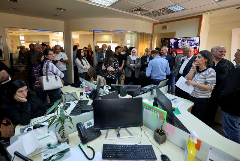 People gather at the Al Jazeera offices in the West Bank city of Ramallah following the killing of the veteran journalist. AFP