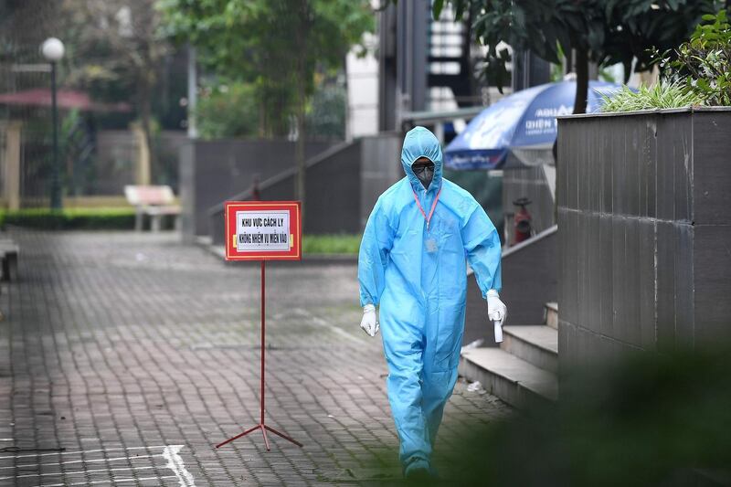 A health worker wearing a protective suit and face mask amid concerns of the spread of the coronavirus walks inside a quarantine area in Thanh Tri district in the suburbs of Hanoi.   AFP