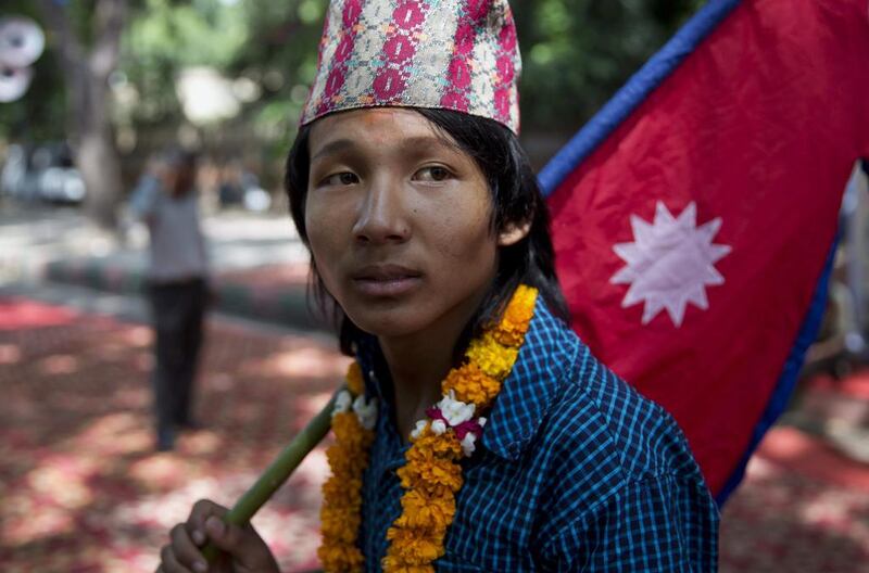 A boy carries the national flag of Nepal during a protest in New Delhi, India. Tsering Topgyal / AP Photo