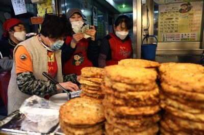 SEOUL, SOUTH KOREA - APRIL 12: Shopkeepers wear masks as they wait for a customer during a Easter holiday Kwangjang market during a Easter as South Koreans take measures to protect themselves against the spread of coronavirus (COVID-19) on April 12, 2020 in Seoul, South Korea. South Korea has called for expanded public participation in social distancing, as the country witnesses a wave of community spread and imported infections leading to a resurgence in new cases of COVID-19. South Korea's coronavirus cases hovered around 30 for the third straight day Sunday, but health authorities are still staying vigilant over cluster infections, as well as new cases coming from overseas. According to the Korea Center for Disease Control and Prevention on Sunday, 32 new cases were reported. The total number of infections in the nation tallies at 10,512. (Photo by Chung Sung-Jun/Getty Images)