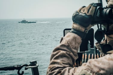 A U.S. Marine observes an Iranian fast attack craft from USS John P. Murtha during a Strait of Hormuz transit, Arabian Sea off Oman, in this picture released by U.S. Navy on July 18, 2019.. Donald Holbert/U.S. Navy/Handout via REUTERS ATTENTION EDITORS- THIS IMAGE HAS BEEN SUPPLIED BY A THIRD PARTY.