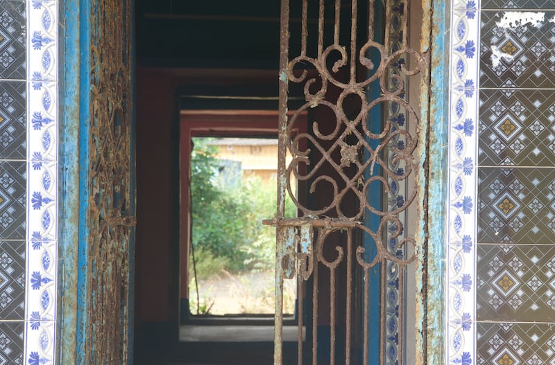 Name plates still hang outside the neatly painted entrances; inside tattered clothes and slippers strewn on the floor—a remnant of their former owners—with walls still adorned with beautiful hand painted vines.