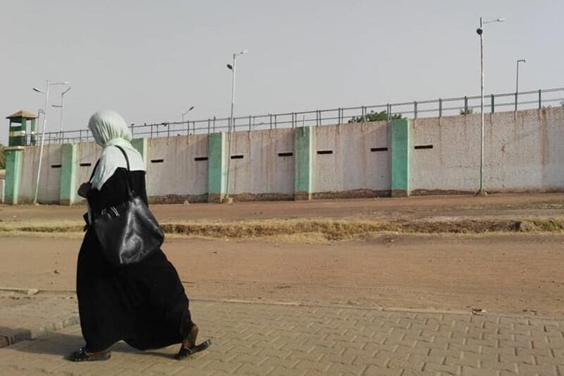 A Sudanese woman walks by the walls of Kober prison where ousted president Omar al-Bashir is detained in Khartoum North, north of the capital Khartoum, on April 17, 2019. Sudan's military rulers have transferred ousted president Omar al-Bashir to prison, a family source said Wednesday, as an array of protest groups marched through Khartoum to join a sit-in at the army complex. Following the dramatic end to Bashir's rule of three decades last week, he was moved late Tuesday to Kober prison in the capital, the source said without revealing his name for security reasons. / AFP / -
