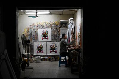 An artist paints in a workshop in Dafen Village