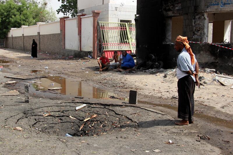 Aden residents inspect the site of a car bomb attack that targeted a police station.  EPA