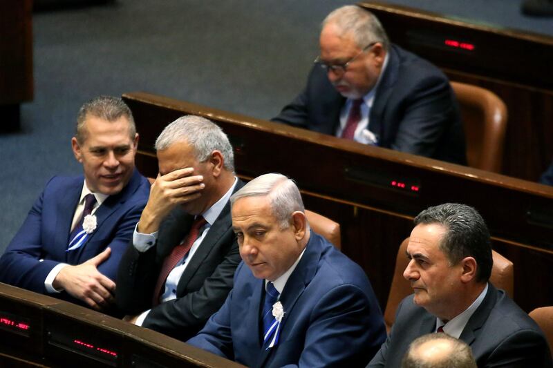 Israeli Prime Minister Benjamin Netanyahu (3rd-L) waits to be sworn in in parliament during the special opening session of the 21st Knesset (Israeli parliament) in Jerusalem on April 30, 2019, next to Likud party MP Gilad Ardan (1st-L), Israeli Minister of Finance and leader of the Israeli "Kulanu" party Moshe Kahlon (2nd-L) and Israel's Minister of Foreign Affairs Israel Katz (1st-R). Prime Minister Benjamin Netanyahu was sworn into Israel's new parliament on april 30 following his victory in April 9 elections and will seek to form a governing coalition in the days ahead. Netanyahu was among the 120 members of the Knesset, or parliament, sworn in during an official ceremony. / AFP / GALI TIBBON

