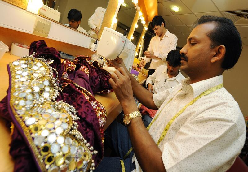 Prakash Bhai Mitna, master tailor, The Merchants of Bollywood, making adjustments to costumes.