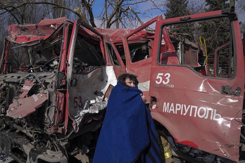 A woman next to a fire truck after shelling in Mariupol, Ukraine. Photo: Evgeniy Maloletka / Associated Press