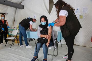 A woman receives a dose of a Covid-19 vaccine in the refugee camp in Greece. AFP 