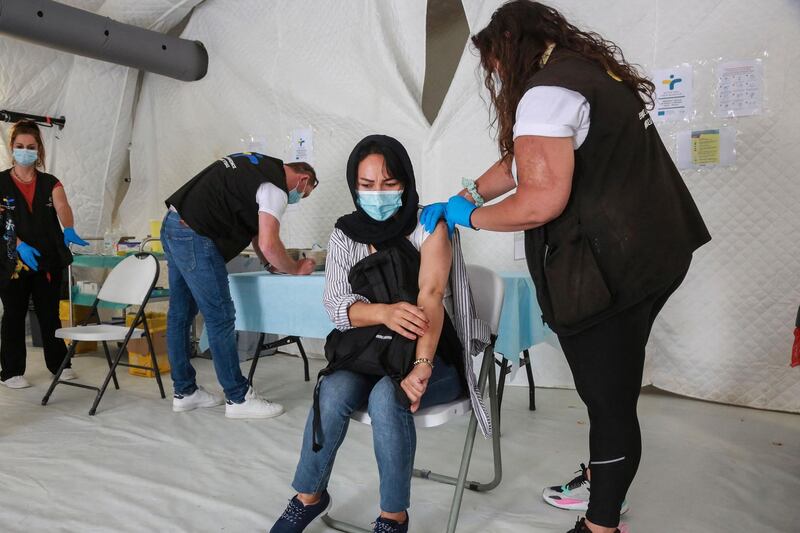 A woman receives a dose of a Covid-19 vaccine in the refugee camp of Mavrovouni in the Greek island of Lesbos on June 3, 2021. / AFP / Manolis Lagoutaris

