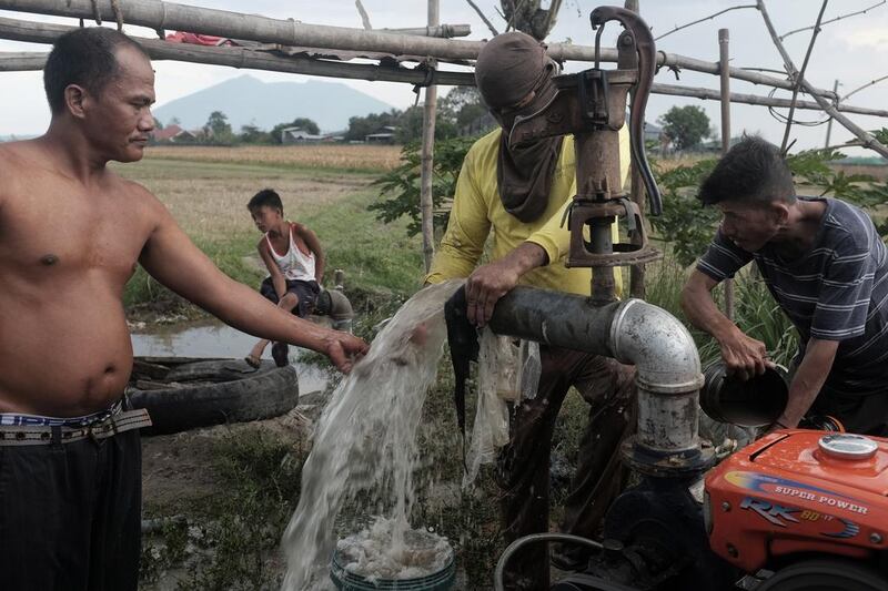 Men work on setting up a water pump in Mabalacat Pampanga. In the Philippines, 10 per cent of the workforce lives abroad and almost half of them are young women, leaving dad’s to raise families.