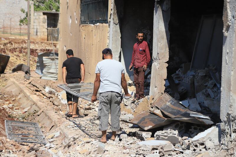 Residents help clear rubble from the White Helmets centre in Sahl Al Rouj in Idlib, Syria after air strikes.