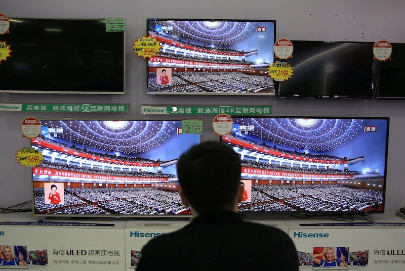 A man watches a broadcast of Chinese President Xi Jinping deliver his speech to open the congress. Reuters