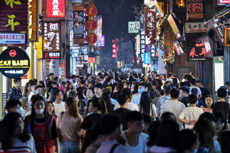 People walk along a pedestrian street surrounded by small shops in the city of Changsha, in the Chinese province of Hunan. China accounts for 19 per cent of the world's total population. AFP