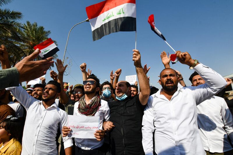Iraqi demonstrators chant slogans during a gathering in Haboubi Square in the southern city of Nasiriyah on October 28, 2020, to demand a total overhaul of a political system. (Photo by Assaad AL-NIYAZI / AFP)