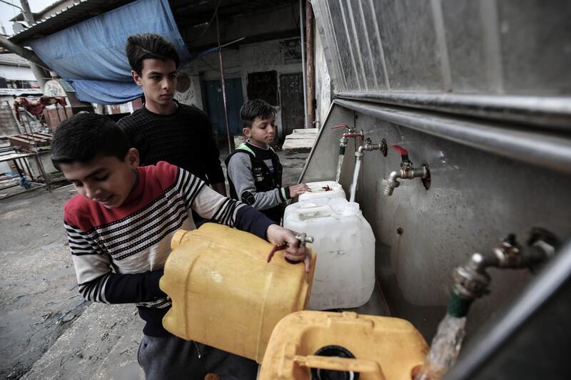 Palestinian youths filling bottles and jerricans with drinking water from public taps at the Rafah refugee camp in the southern Gaza Strip. More and more Gazans are falling ill from their drinking water, highlighting the humanitarian issues facing the Palestinian enclave that the UN says could become uninhabitable by 2020. Said Khatib/AFP